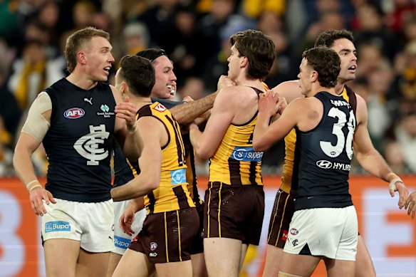 Carlton’s Oliver Hollands and Hawthorn’s Will Day (centre) scuffle.
