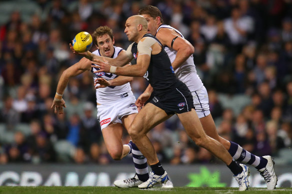 Chris Judd gathers the ball against Michael Barlow and Aaron Sandilands.