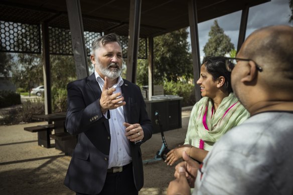 Melton Liberal candidate Graham Watt speaks to Thornhill Park residents Chander and Manisha Sharma.