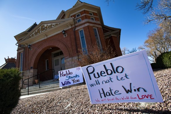 Signs, flowers and candles expressing love for the Jewish community stand outside the Temple Emanuel in Pueblo, Colorado after news of the threat emerged in July 2020. 