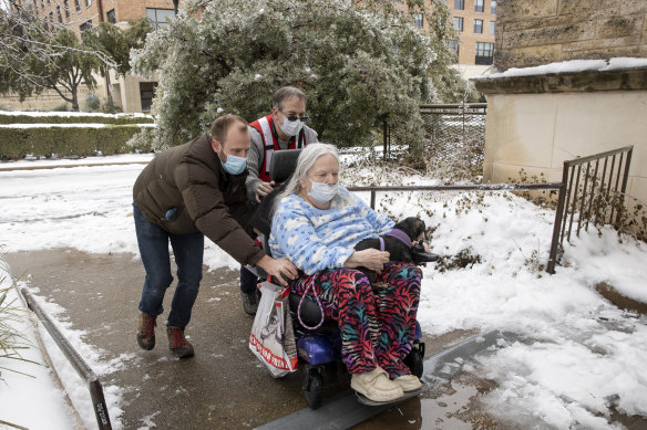 Dori Ann Upchurch is helped by Austin Disaster Relief Network volunteer Cody Sandquist, left, and a Red Cross volunteer to a warming station in Austin, Texas, after being evacuated from her home during last week’s snowstorm. 
