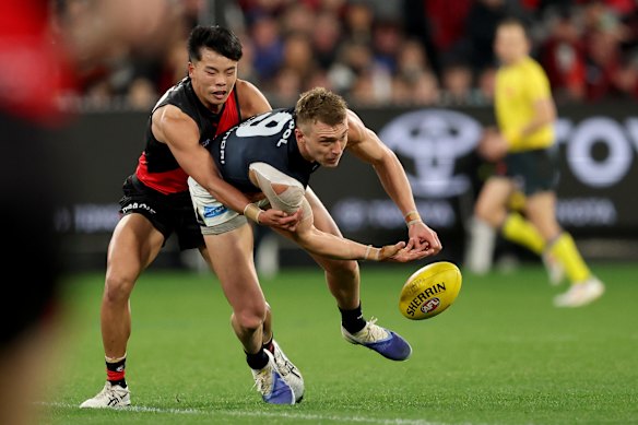 Patrick Cripps of the Blues handballs.