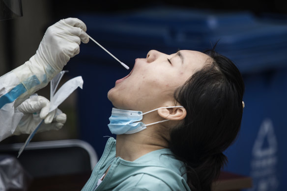A medical worker takes a swab from a Wuhan resident, part of a drive to test 6.5 million people.