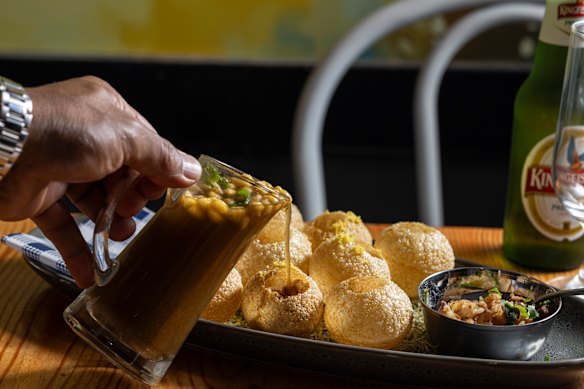  The tamarind-spiced water (pani) is poured into the shells (puri).