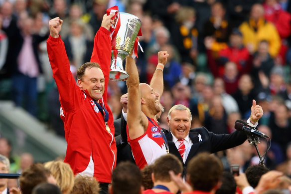 John Longmire and Jarrad McVeigh lift the 2012 premiership trophy.