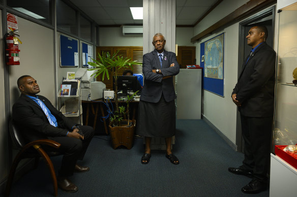 Fijian Home Affairs Minister Pio Tikoduadua (centre), flanked by guards, stands outside the prime minister’s office. 