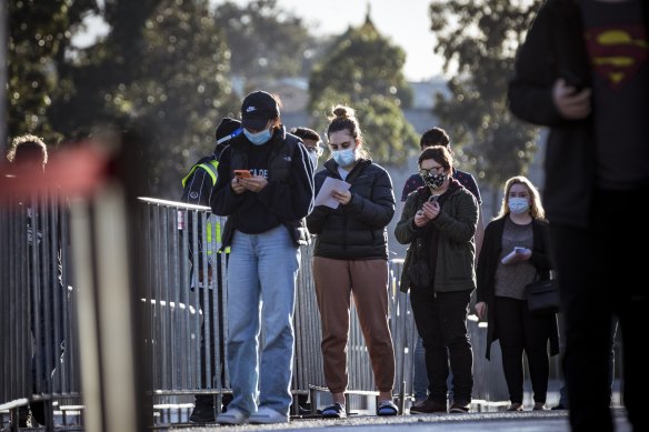 People line up for vaccinations in Melbourne on Wednesday. The federal government wants to open up bookings to whole families in a bid to further speed up the rollout.