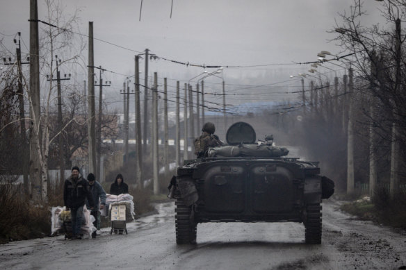 A member of the Ukrainian military drives an infantry fighting vehicle down a residential street in Bakhmut. 
