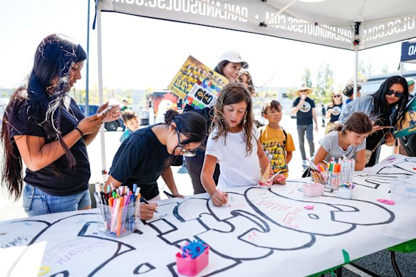Young fans sign a banner of support for the Socceroos.