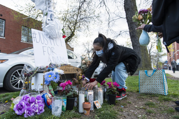 A woman tends to a memorial for Adam Toledo in Chicago.