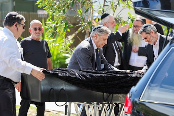 Mourners greet Rabbi Eli Schlanger’s coffin as it arrives at Chabad of Bondi for the funeral on Monday.