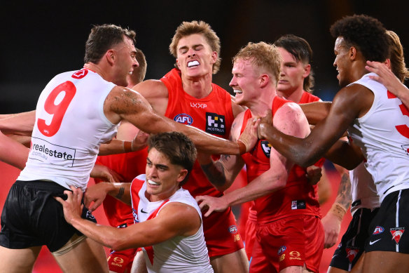 Swans and Suns players wrestle during their pre-season clash on the Gold Coast.