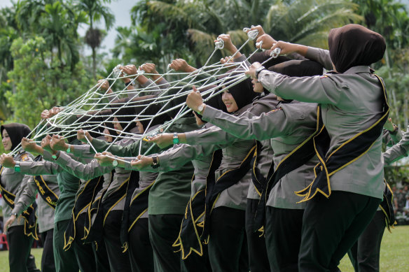 Indonesian women police officers and soldiers, pictured performing a traditional dance, no longer have to submit to invasive virginity tests. 