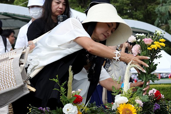 People lay flowers at the Hiroshima Peace Memorial.