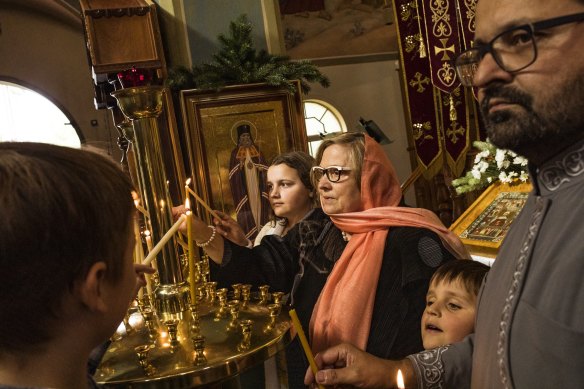  Luba Cowall, her son, Nicholas and her grandchildren, Nicholas, 14, Sophie, 12, and Peter, 7 light a candle for Russian Orthodox Christmas at Holy Protection Cathedral of the Russian Orthodox Church, East Brunswick. 