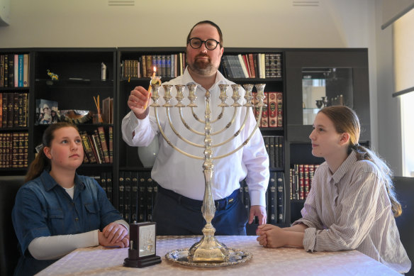 Benjamin Klein and daughters Zahava and Breindy with their menorah. 