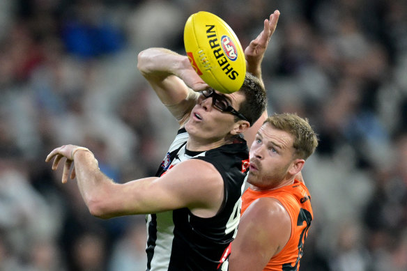 Collingwood’s Mason Cox taps the ball in the ruck against Matt Flynn.