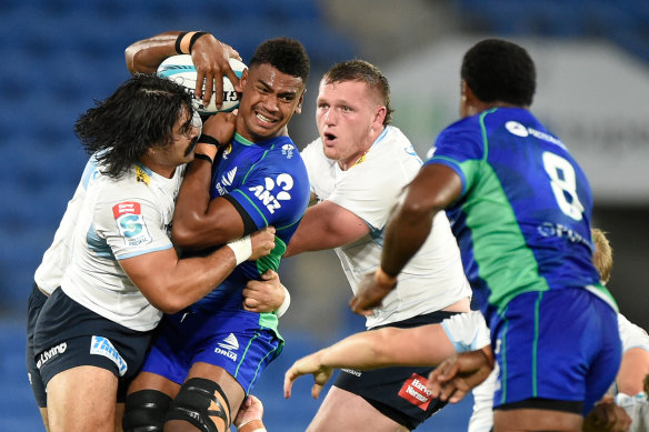 Fijian Drua lock Kitione Salawa is tackled by Waratahs defenders.