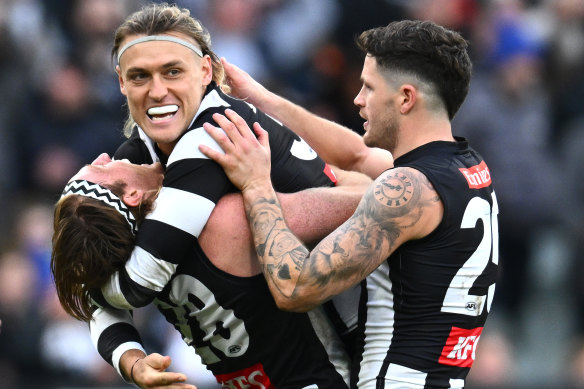 Darcy Moore, Nathan Murphy and Jack Crisp of the Magpies celebrate the win over the Crows, in what was the last round of AFL byes this year.