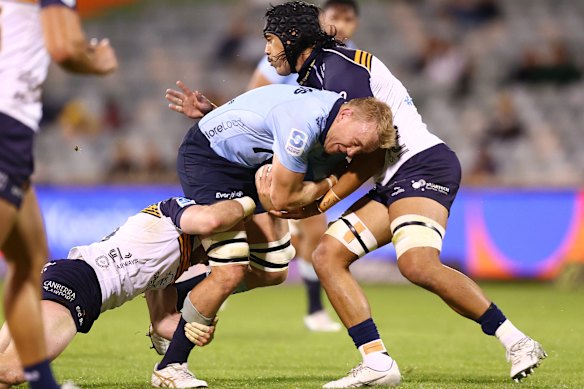 Hugh Sinclair of the Waratahs is tackled  by the Brumbies’ defence