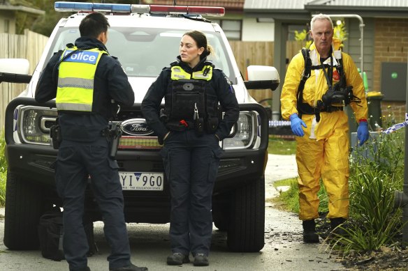 Forensic police in protective gear investigate the house where the bodies of four people were found in Broadmeadows.