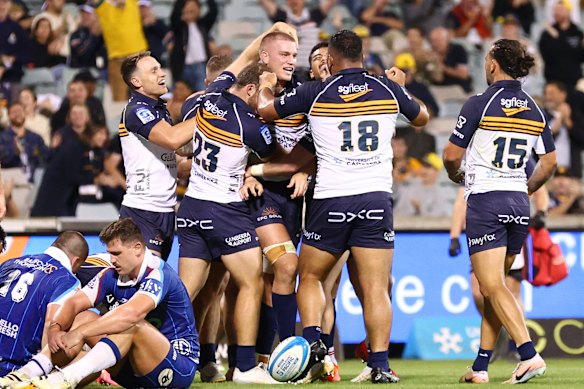 Brumbies players celebrate a winning try by Charlie Cale against the Blues.