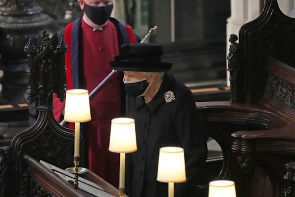 Britain’s Queen Elizabeth II takes her seat alone in St. George’s Chapel during the funeral of Prince Philip.