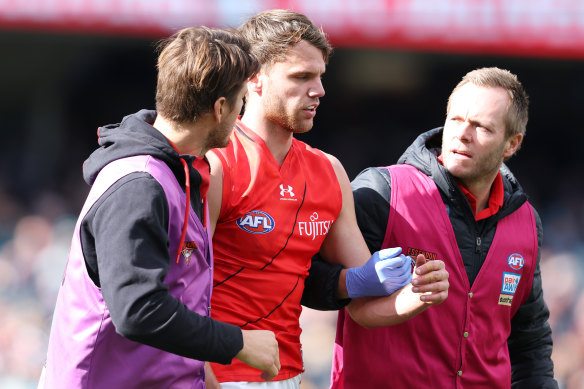 A concussed Jordan Ridley is helped off Adelaide Oval.