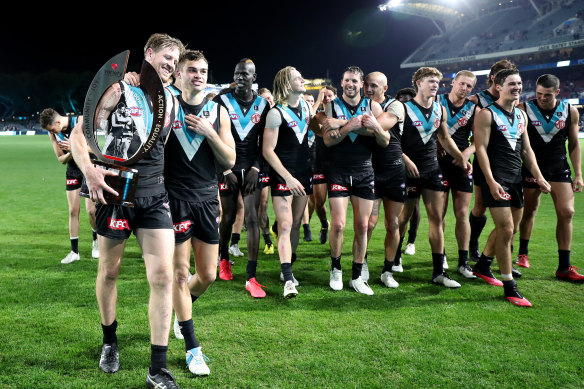Tom Jonas, Karl Amon and Port players walk off with the Showdown Trophy after beating Adelaide on Saturday night.