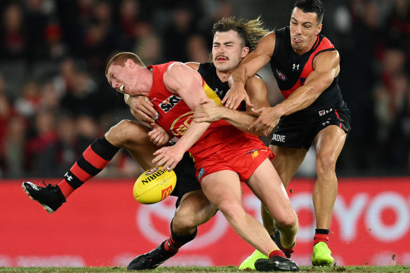 Young Suns star Matt Rowell is tackled by two Essendon opponents in round two.