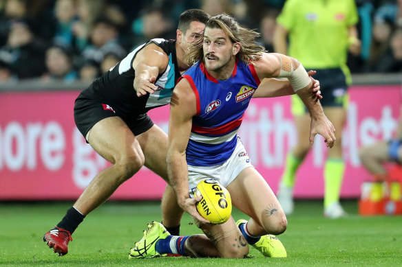 Josh Bruce looks to get the ball away for the Bulldogs as Ryan Burton tackles.