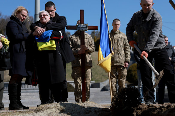 Yuri Vododymyrovych hugs his mother, Myroslava, as they grieve next to the grave of his twin brother Fedorchyk Ihor  at the Lychakiv Cemetery in Lviv, Ukraine on Thursday. Fedorchyk was a member of the Ukrainian Army and died fighting the Russians in the city of Nova Kakhovka. 