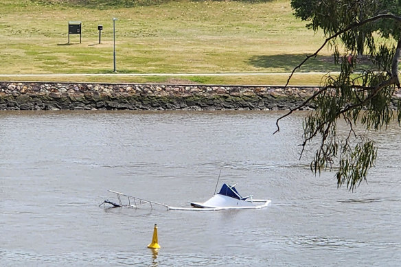 A largely submerged cruiser in the Brisbane River after a collision with a CityCat.