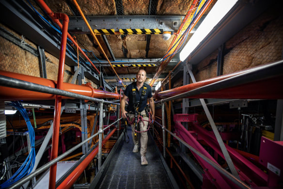 Opera House building operations manager Dean Jakubowski makes his way through the passage to the crawl space leading to the top shell of the sails on section A2. 