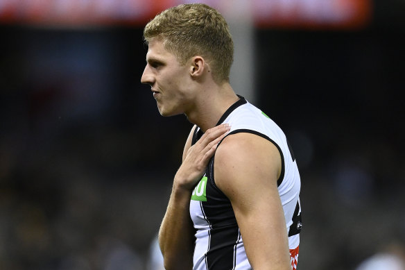 An injured Will Kelly of the Magpies grabs at his collarbone in Friday night’s clash with the Tigers