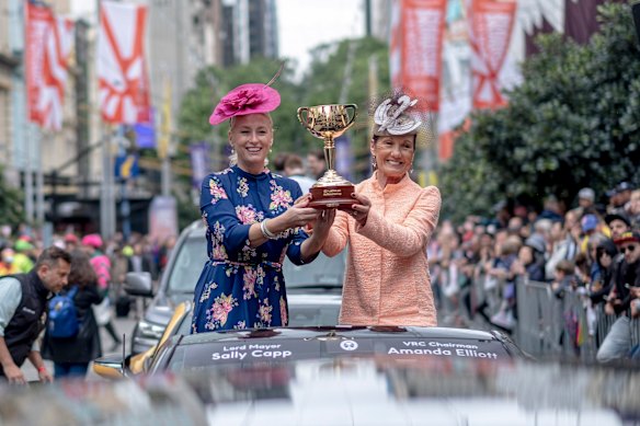 Lord mayor Sally Capp with VRC chairman Amanda Elliott holding the Melbourne Cup during the parade in 2019.