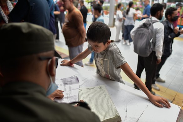 A boy examines the list of missing flood victims outside the emergency ward.