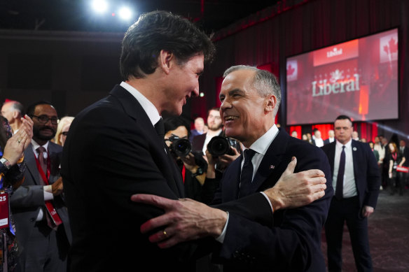 Mark Carney, right, speaks to Justin Trudeau after Carney was announced as the winner of the party leadership.