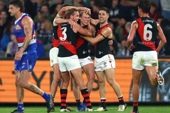 Xavier Duursma of the Bombers is congratulated by teammates after kicking a goal.