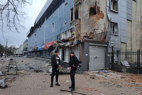 Mayor of Chernihiv Vadyslav Atroshenko, right, speaks to a journalist near the shopping mall damaged by night shelling.