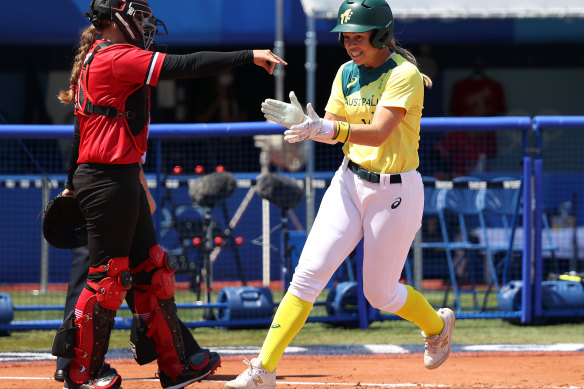 Stacey Porter celebrates as she scores the first run of the game.