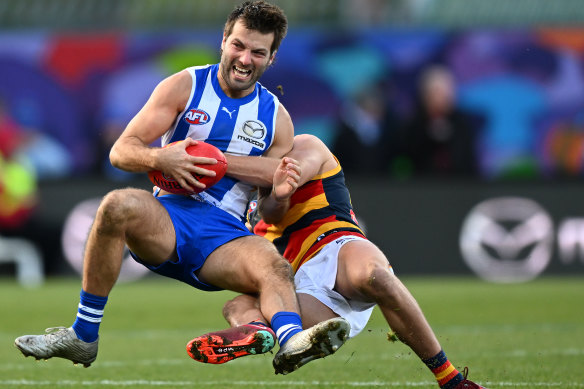 Crow  Mitchell Hinge ferociously tackles Luke McDonald of the Kangaroos.