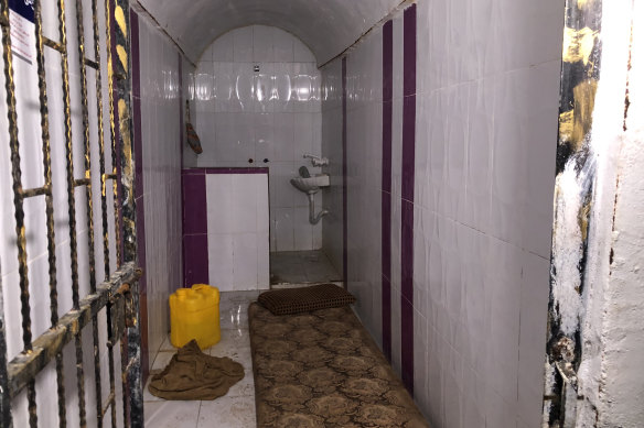 A view of a small cell from the entrance, where there is a barred door open.