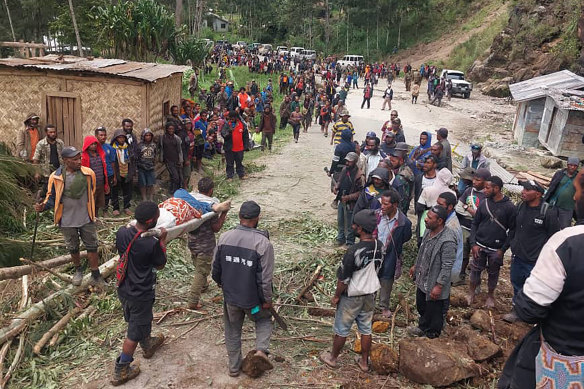 An injured person is carried on a stretcher to seek medical assistance after a landslide in Yambali village.