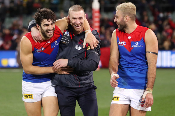 Christian Petracca, Simon Goodwin and Christian Salem celebrate a win during their premiership season.