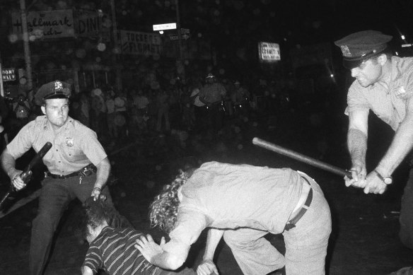 A New York police officer grabs a youth by the hair as another officer clubs a young man during a confrontation in Greenwich Village on August 31, 1970.