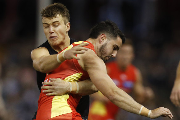 Brayden Fiorini of the Suns is tackled by Patrick Cripps of the Blues.