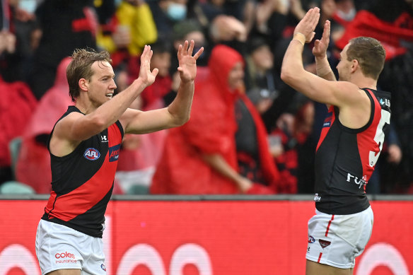 Darcy Parish is congratulated by Devon Smith after kicking a goal.