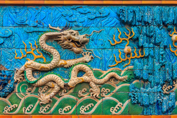 Detail of the Nine Dragon Wall of marble carving of dragons playing with pearls at the Forbidden City.