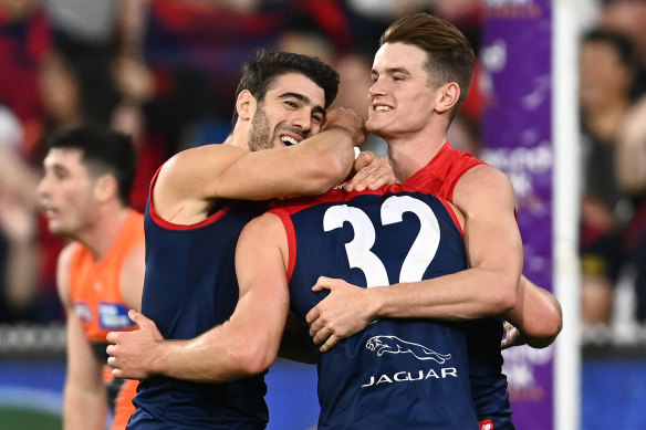 Tom Sparrow, Christian Petracca and Bayley Fritsch celebrate a goal. 